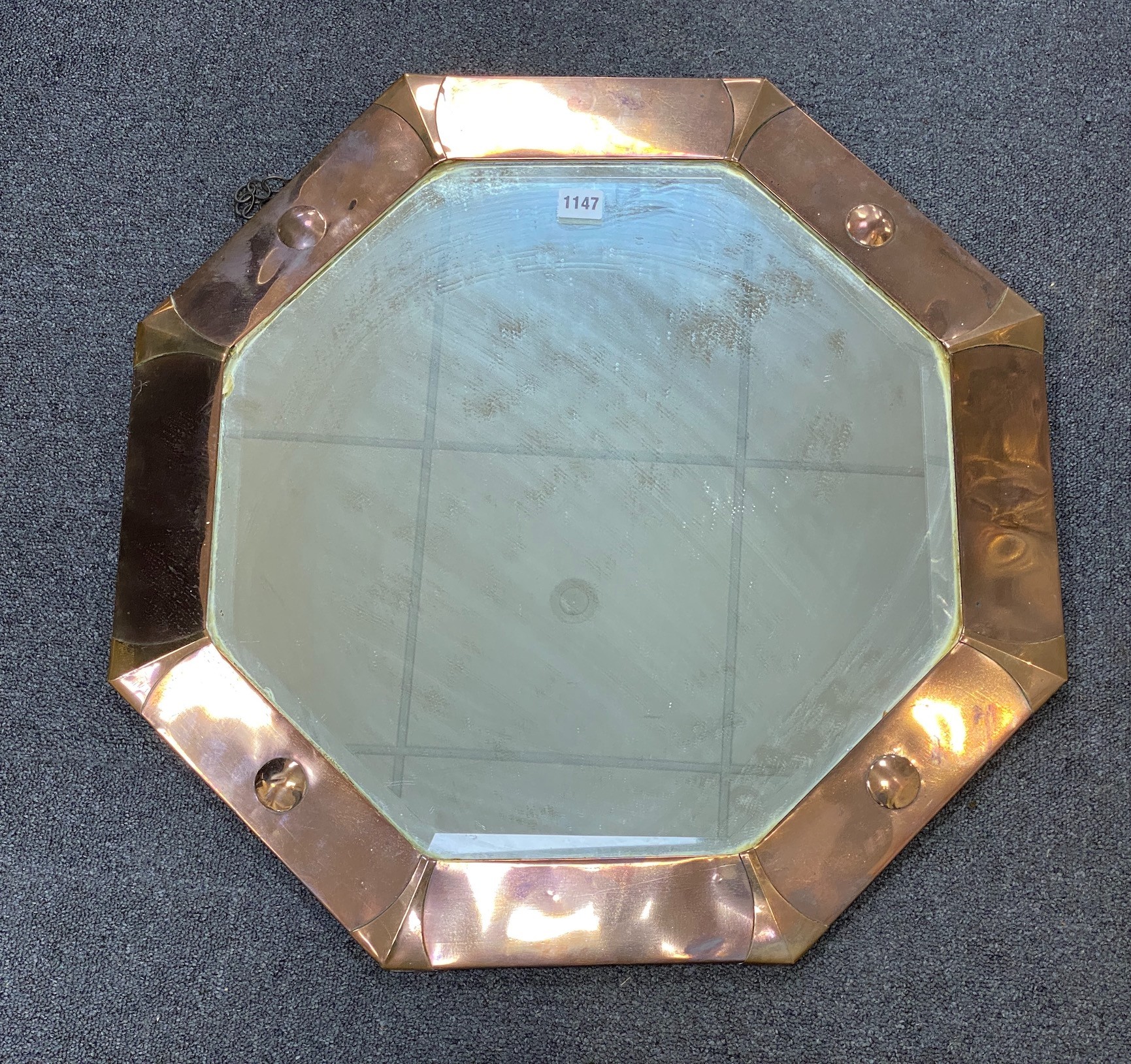 An Arts and Crafts octagonal copper framed wall mirror, width 63cm